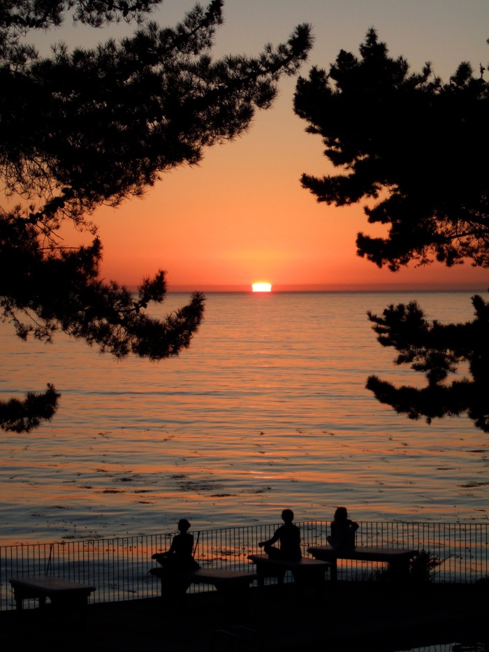 People meditating at sunset